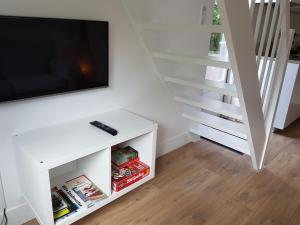- un salon avec une télévision sur une table blanche dans l'établissement Picco Bello, à Zandvoort