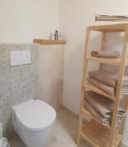 a bathroom with a toilet and a shelf with towels at LieblingsOrt in Neusiedl am See