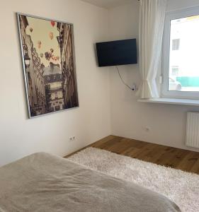 a bedroom with a flat screen tv on the wall at LieblingsOrt in Neusiedl am See