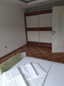 a bedroom with a white bed with towels on it at Loznicki stan na dan 2 - stan na dan Loznica in Loznica