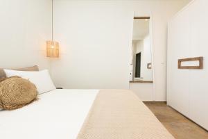 a bedroom with a white bed and a mirror at Konstantinou Deluxe Apartments in Skala Marion