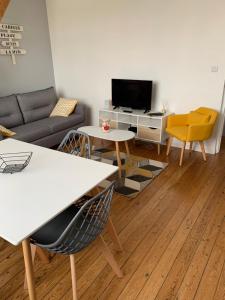 a living room with a couch and a table at Le Phare de Cati in Mers-les-Bains