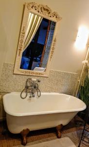 een bad in de badkamer met een spiegel en een fiets bij Royal Hubert in Provins