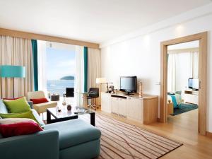 a living room with a couch and a tv at Sun Gardens Dubrovnik in Dubrovnik