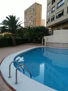a large blue swimming pool next to a building at Coblanca in Benidorm