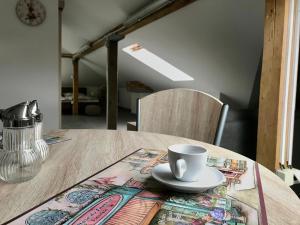 布拉格的住宿－Apartmán U babičky，一张木桌,上面有杯子和盘子