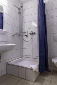bagno con vasca e lavandino di Motel Drei König- Ihr Transithotel a Heimsheim