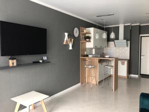 a living room with a tv on a wall at Apartment on Bratskaya 6 in Minsk