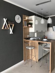 a kitchen with a counter and a clock on the wall at Apartment on Bratskaya 6 in Minsk