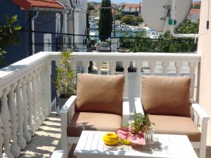 d'un balcon avec deux chaises et une table sur une balustrade blanche. dans l'établissement Apartmani Bruna, à Jezera