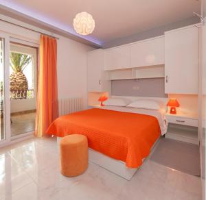 a bedroom with a large bed with an orange blanket at Apartments Milana in Tučepi