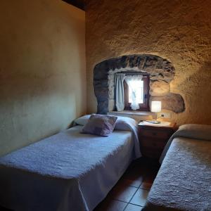 een slaapkamer met 2 aparte bedden en een raam bij Les Cases De Borrells in Lladurs