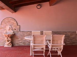 a table and chairs in front of a brick wall at Appartamento in Villa Andreina - Seminterrato in Orosei