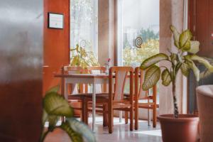 a dining room with a table and chairs and plants at Hotel Güleryüz 2 in Antalya