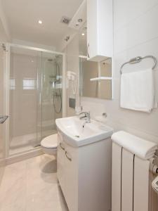 a white bathroom with a toilet and a sink at Apartments Milana in Tučepi +58 photos