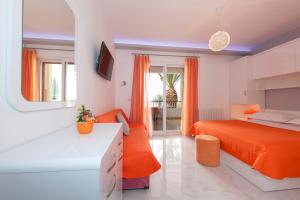 a bedroom with an orange bed and a desk at Apartments Milana in Tučepi