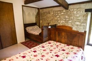 a bedroom with a bed with a floral bedspread at CHEZ SIMONE in Senouillac