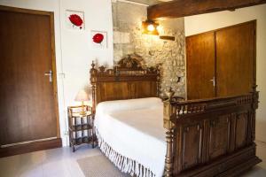 ein Schlafzimmer mit einem großen Holzbett in einem Zimmer in der Unterkunft CHEZ SIMONE in Senouillac