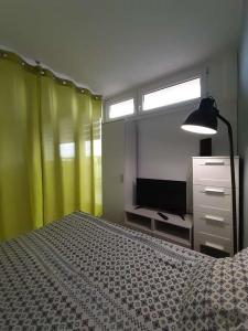 a bedroom with a bed and a lamp and a television at Apartament Ostrowskiego in Wrocław