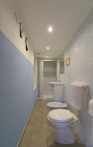 a bathroom with a white toilet and a sink at La casa nel bosco-senza auto in Ponte della Venturina