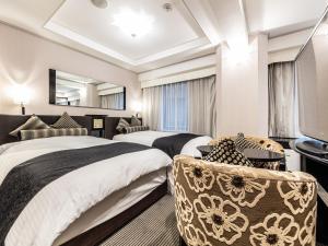a hotel room with two beds and a flat screen tv at APA Hotel Roppongi SIX in Tokyo