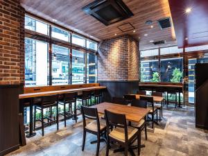 a restaurant with wooden tables and chairs and windows at APA Hotel Roppongi SIX in Tokyo