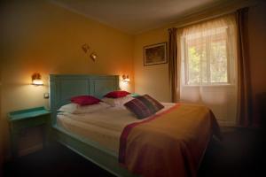 锡纳亚巴斯蒂翁酒店的一间卧室，有一张带红色枕头的床和一扇窗户 更多61张照片