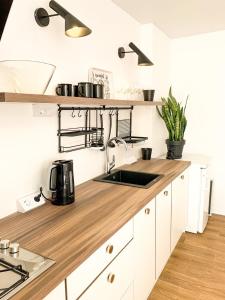 a kitchen with white cabinets and a wooden counter top at Birdie Home at Nauky metro in Kharkiv