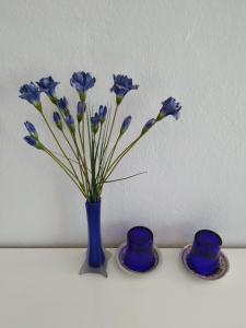 a blue vase with blue flowers on a table at Vivenda Familia Pedro in Vila do Bispo
