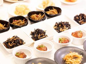 a table topped with white dishes filled with food at APA Hotel Roppongi SIX in Tokyo