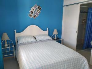 a blue bedroom with a white bed and a blue wall at Vivenda Familia Pedro in Vila do Bispo
