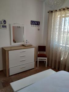 a bedroom with a dresser and a mirror at Vivenda Familia Pedro in Vila do Bispo