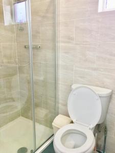 uma casa de banho com um WC e um chuveiro em London Luxury 2Bedrooms, Reception, Garden, Apartment em Ilford