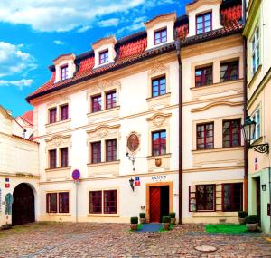 un grand bâtiment blanc avec un toit rouge dans l'établissement Hotel Waldstein, à Prague