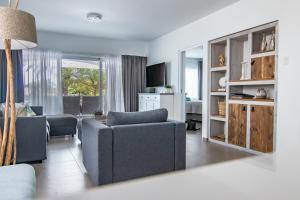 a living room with a couch and a chair at Palms & Pools apartment at Curacao Ocean Resort in Willemstad