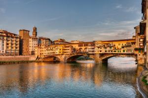 Ponte Vecchio View Luxury Apartment في فلورنسا: جسر فوق نهر في مدينة بها مباني