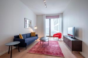 ein Wohnzimmer mit einem blauen Sofa und einem roten Stuhl in der Unterkunft PREMIER SUITES PLUS Amsterdam in Amsterdam