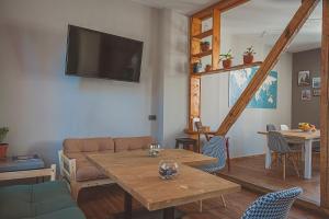 a living room with a table and a tv at Temple House in Plovdiv