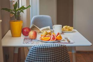 a table with a plate of fruit and a book at Temple House in Plovdiv