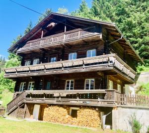 een groot houten huis met een balkon aan de zijkant bij Villgratenhaus in Außervillgraten