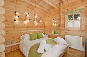 a bedroom with a bed in a wooden cabin at The Lodge with hot tub in Maidstone