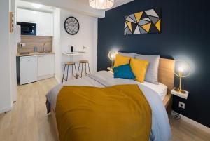 a bedroom with a large bed with a yellow blanket at Studio Cosy - Parking - Wifi - Buanderie - Jardin in Brest