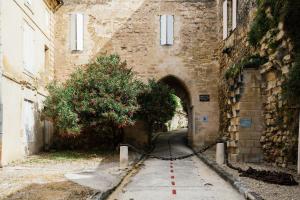 un callejón en un edificio de piedra con un túnel en Appartement spacieux et lumineux avec climatisation et belle hauteur sous plafond - Halle 2EME, en Castillon-la-Bataille