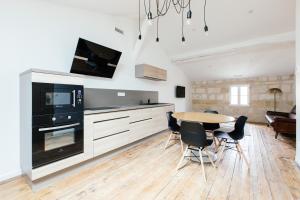 een keuken en eetkamer met een tafel en stoelen bij Appartement spacieux et lumineux avec climatisation et belle hauteur sous plafond - Halle 2EME in Castillon-la-Bataille