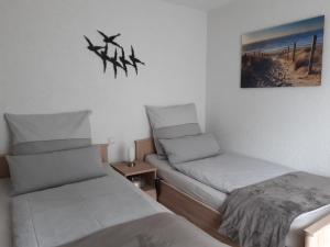 a room with two beds and a picture on the wall at Kurpension Meßmer in Tengen
