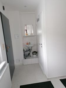 Baño blanco con lavabo y aseo en Apartment North City Hannover, en Hannover