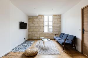 een woonkamer met een blauwe bank en een tafel bij Appartement spacieux et lumineux avec climatisation Halle 1ER in Castillon-la-Bataille