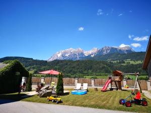 a backyard with a playground with mountains in the background at Stögergut by Schladming-Appartements in Schladming