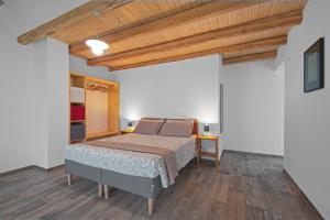 1 dormitorio con cama y techo de madera en lioelara, en Feltre
