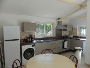 a kitchen with a table and a washer at Maisonnette au calme et proche mer in Mandelieu-La Napoule